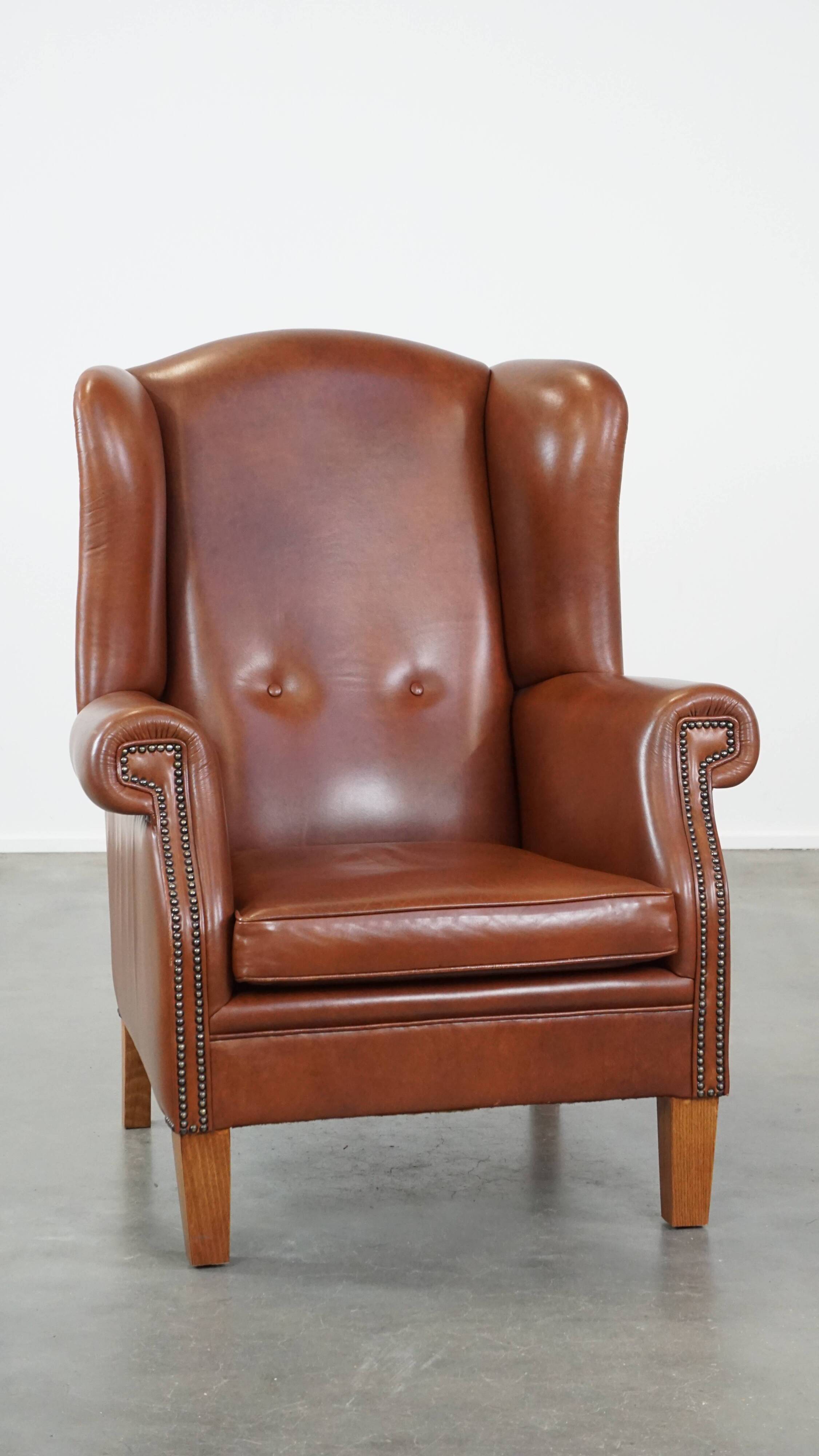 Cognac-colored leather wingback chair in English style
