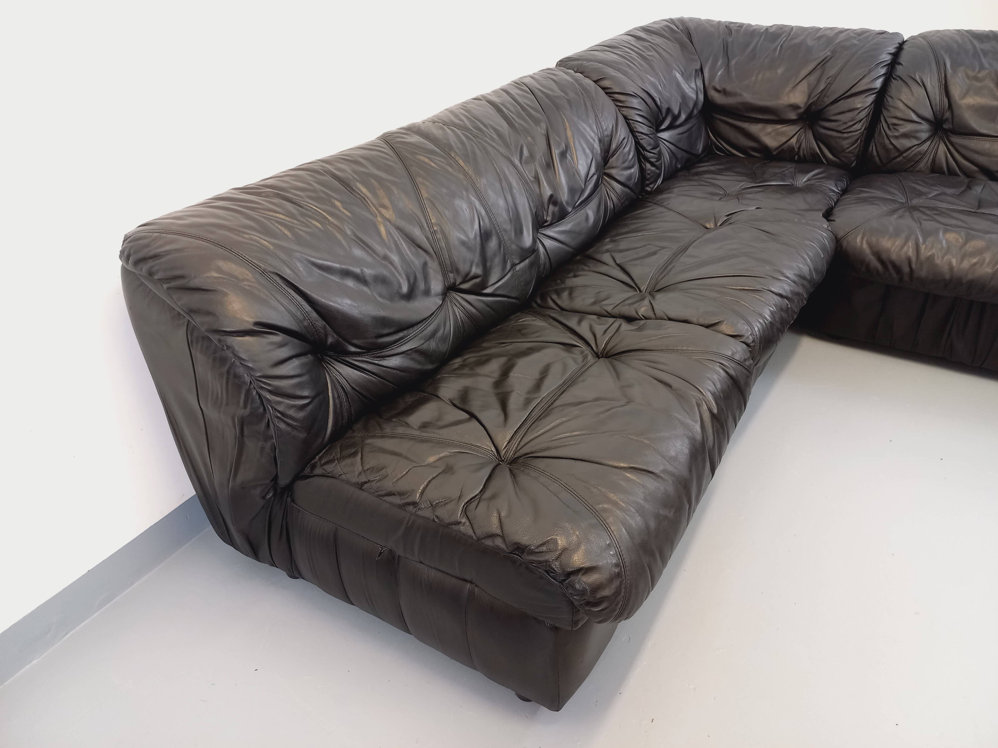 Vintage corner sofa composed of 3 modules in black leather with integrated bed.