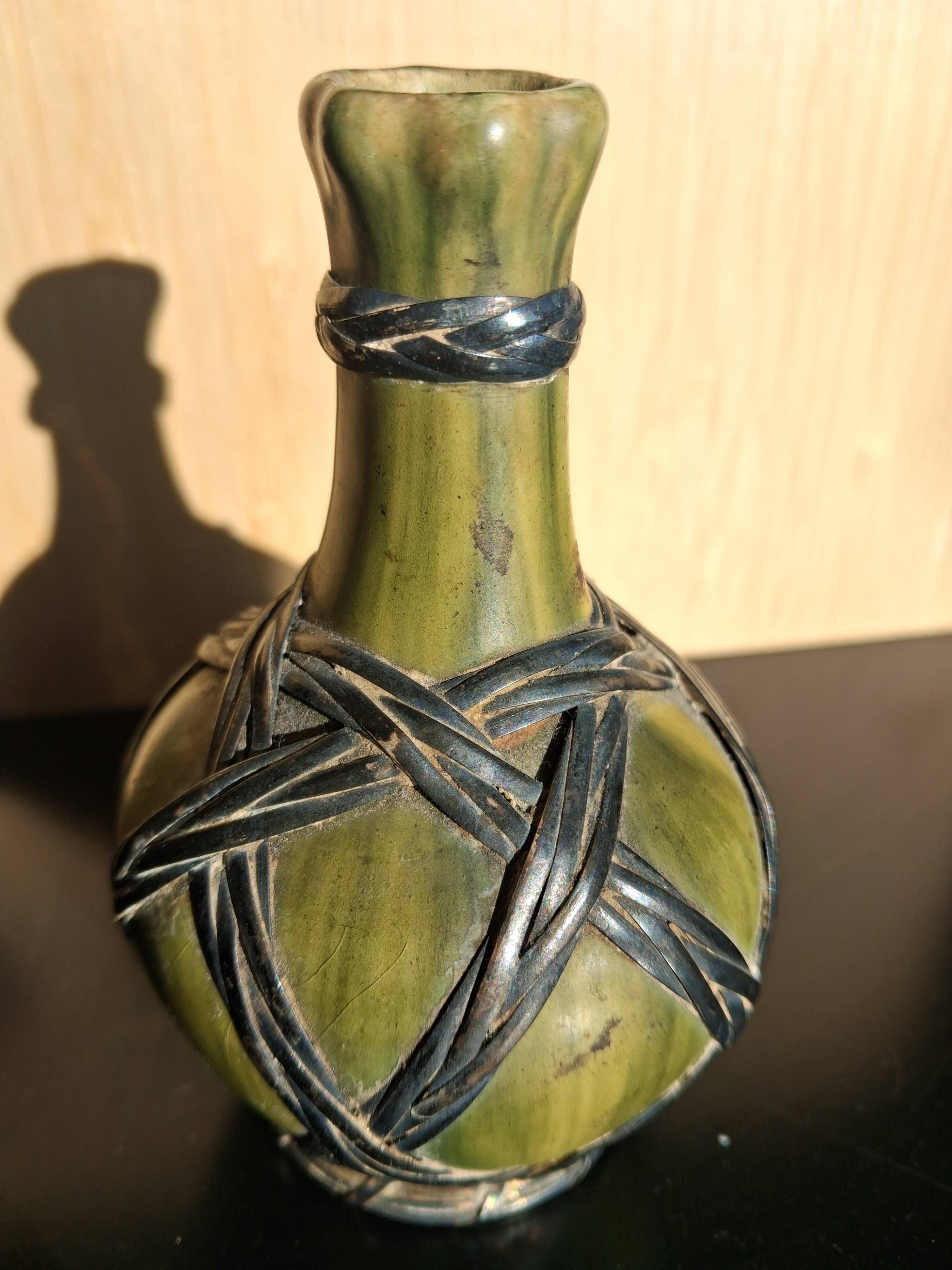 Miniature vase encircled with woven black brass.