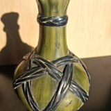 Miniature vase encircled with woven black brass.