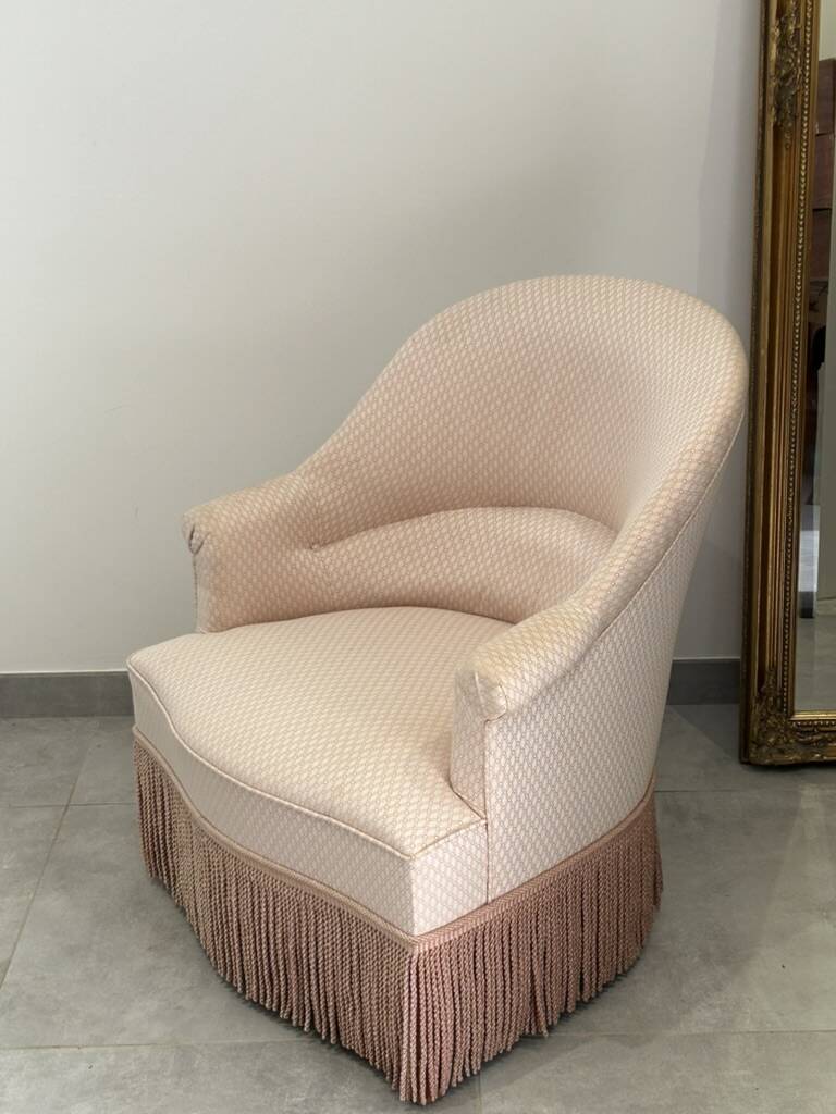Pink armchair with patterns and fringes.