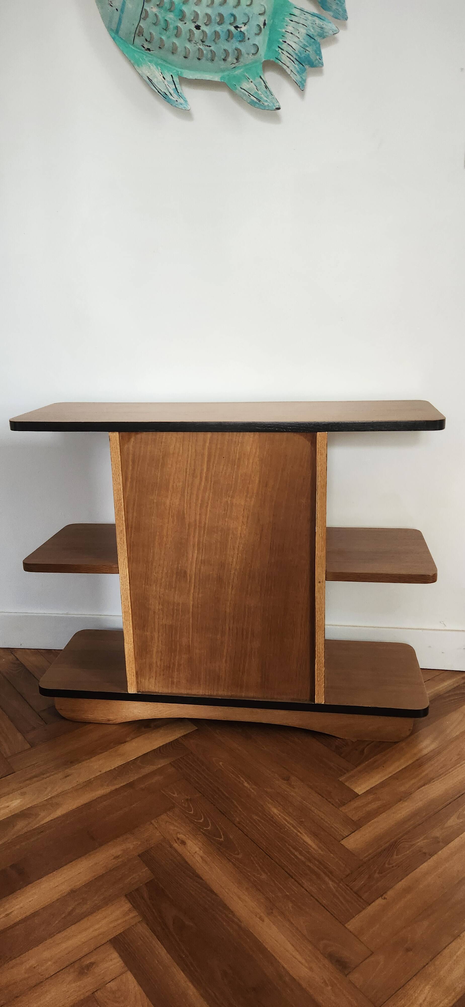 Compact bar cabinet with a pivoting door in black wood.