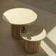 Round nesting coffee table in travertine and raw fluted wood.