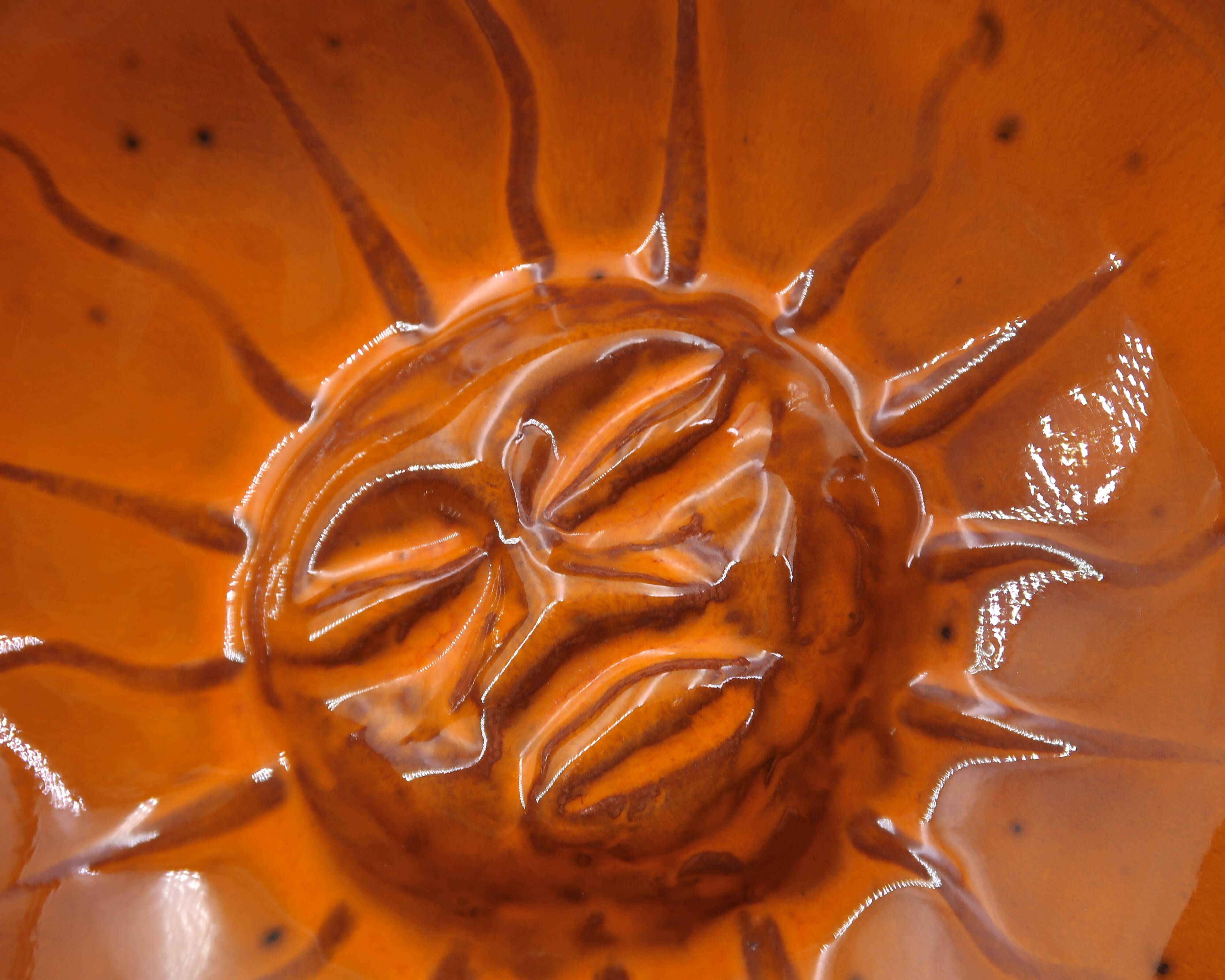 Mexican ceramic catchall in orange and black, 1970s sun face.