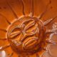 Mexican ceramic catchall in orange and black, 1970s sun face.