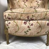Paire de bergères en bois doré garnies de soie à motifs de fleurs, art déco d’inspiration Louis XVI