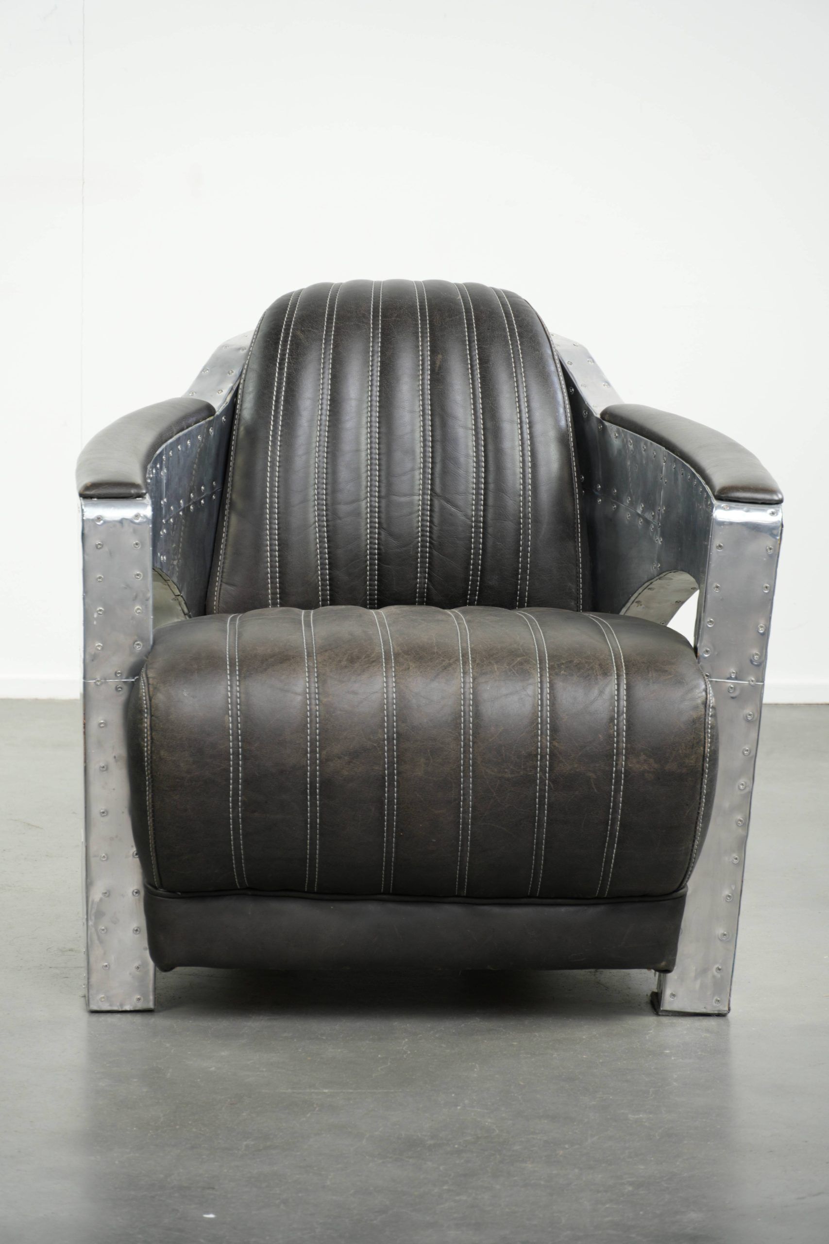 Cow leather aviator design armchair finished with aluminium and rivets