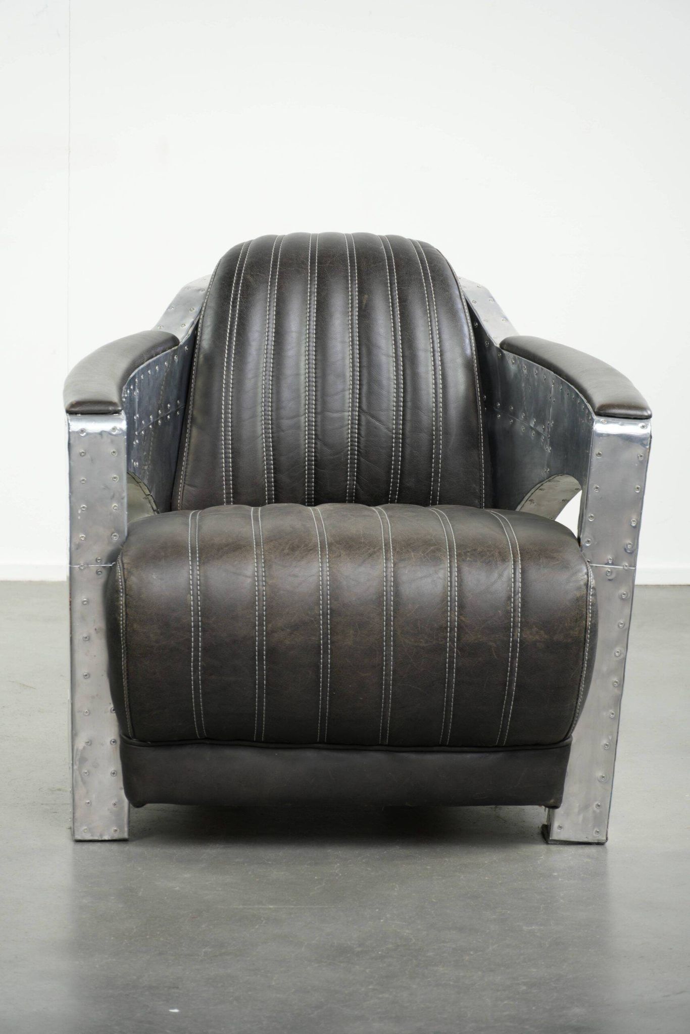 Cow leather aviator design armchair finished with aluminium and rivets