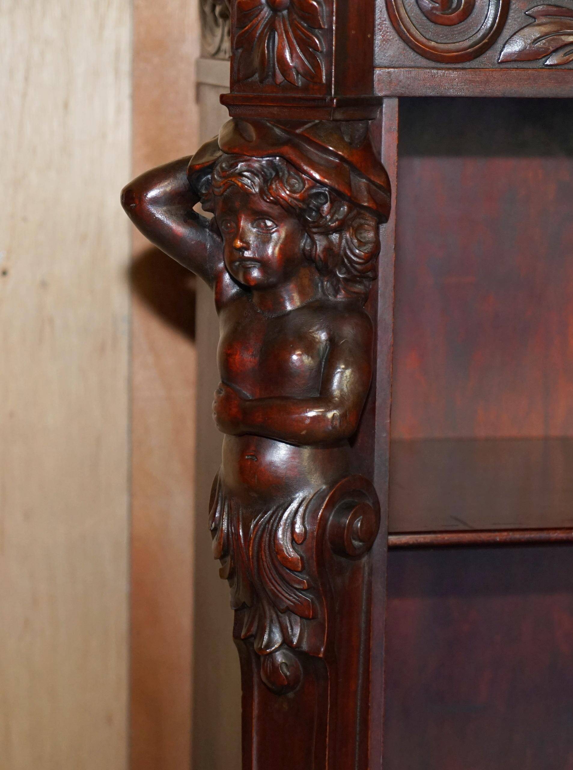Hand-carved library circa 1900 in hardwood with Hermes statues.