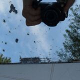 Beveled mirror with art-deco wrought iron frame and floral decor with hanging chain