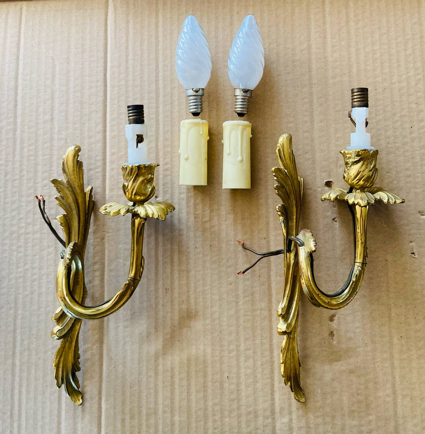 Bronze wall lights in the Louis XV style with curved branches and leaf decorations.