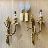 Bronze wall lights in the Louis XV style with curved branches and leaf decorations.