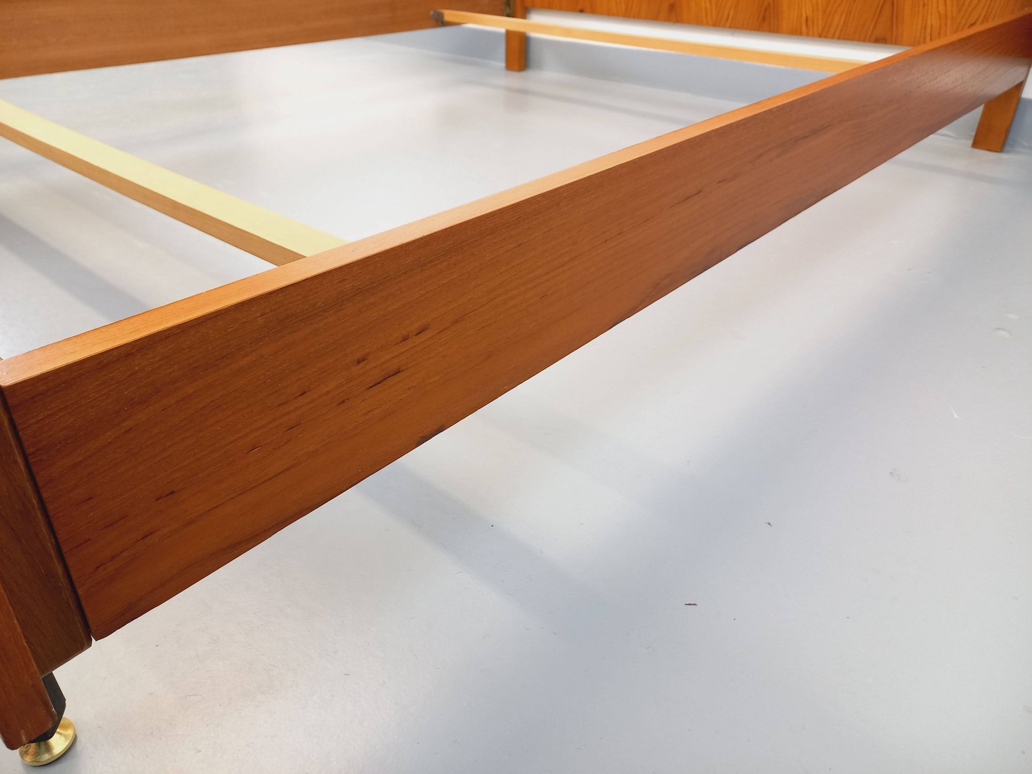 Double bed vintage modernist in teak and black metal from the 1960s with bedside tables.
