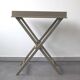 Folding and removable service tray in taupe-painted wood.