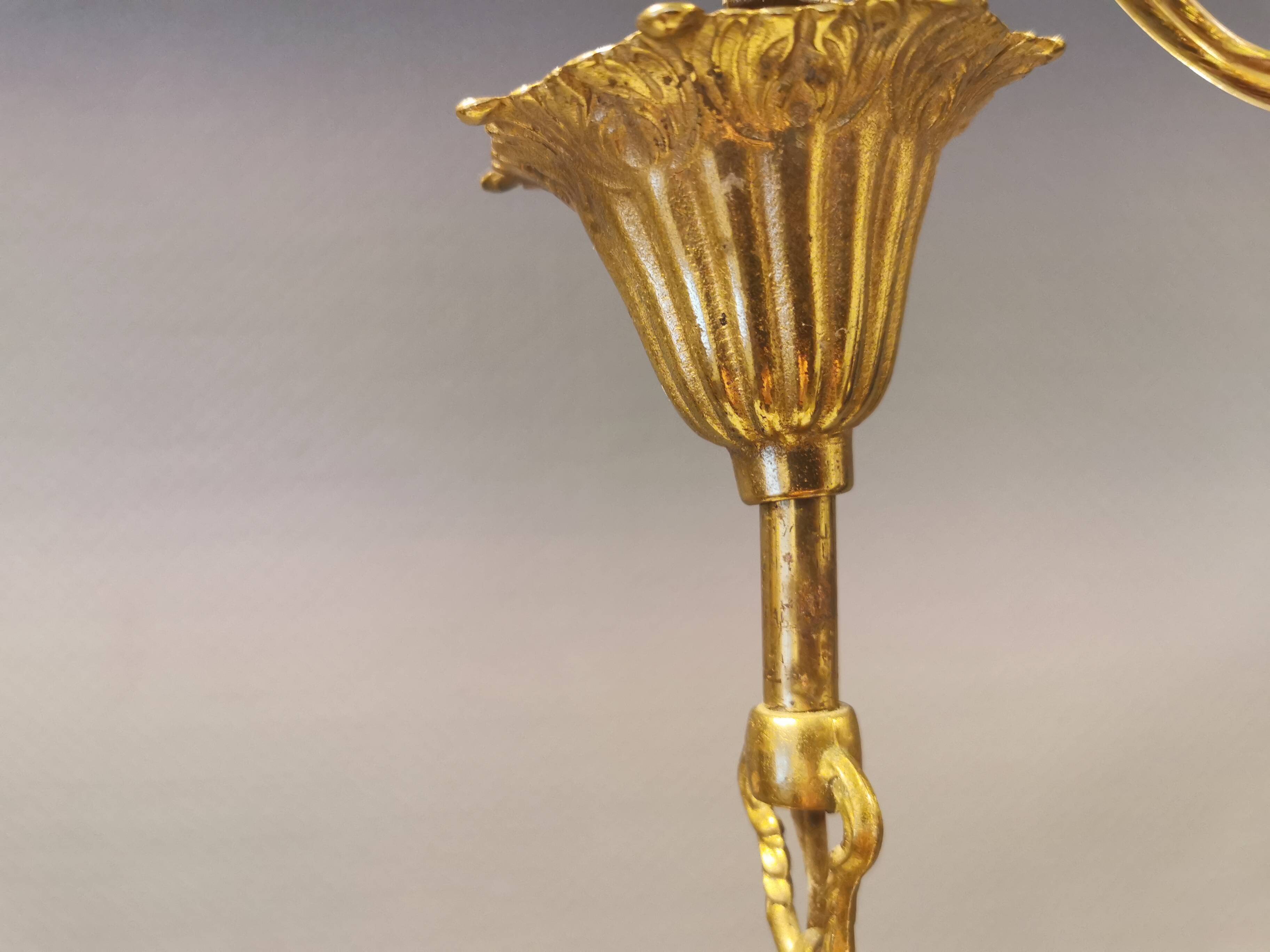 Older brass alloy chandelier with three light sources.