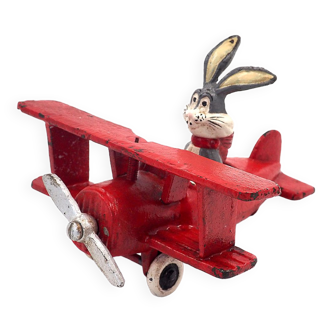 Toy Bugs Bunny figure in a cast iron biplane approximately 1948