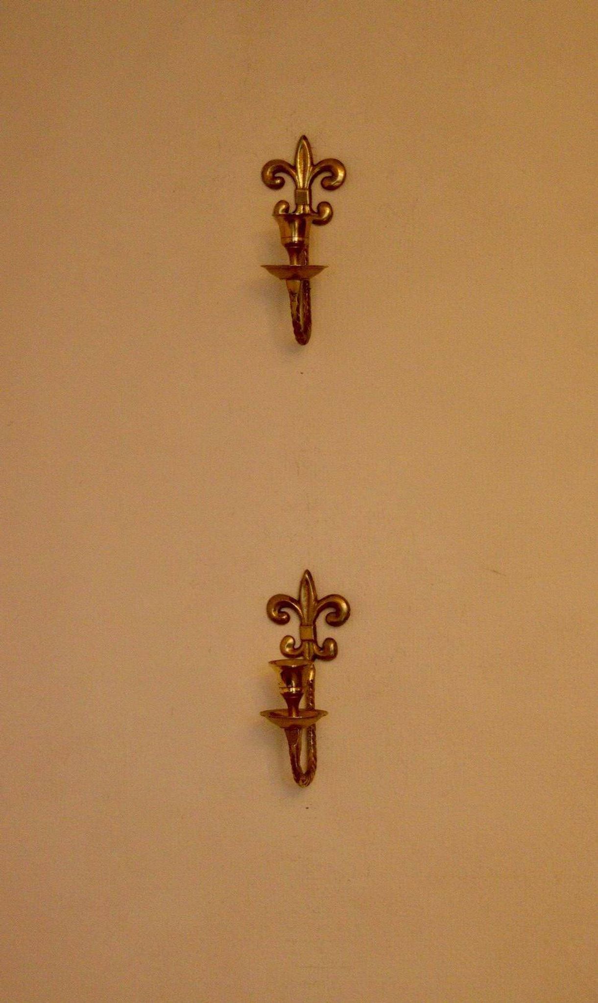 A pair of antique brass wall sconces.