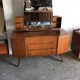 Vintage 1950s brown wooden dressing table with a double mirror and integrated storage.