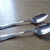 2 small white metal spoons