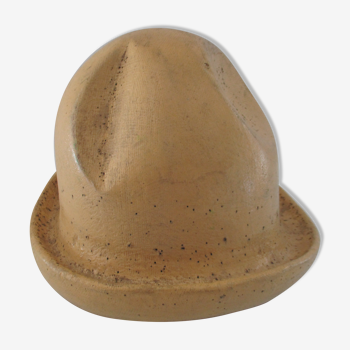 Shape of pressed plaster hat with surface and textile fiber of yellowish color,