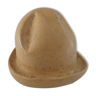 Shape of pressed plaster hat with surface and textile fiber of yellowish color,