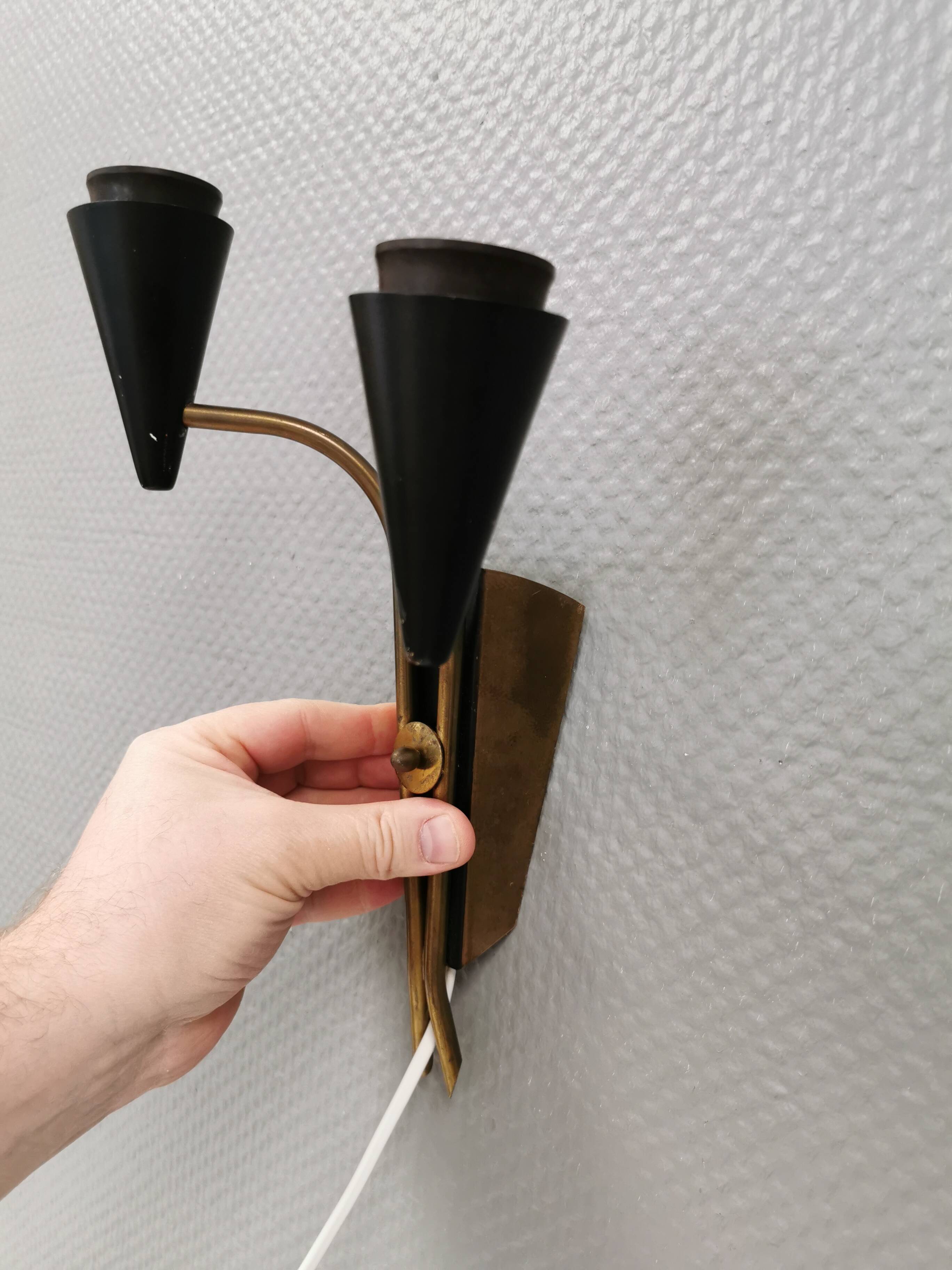 A set of wall lamps in black lacquered metal with brass details