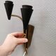 A set of wall lamps in black lacquered metal with brass details