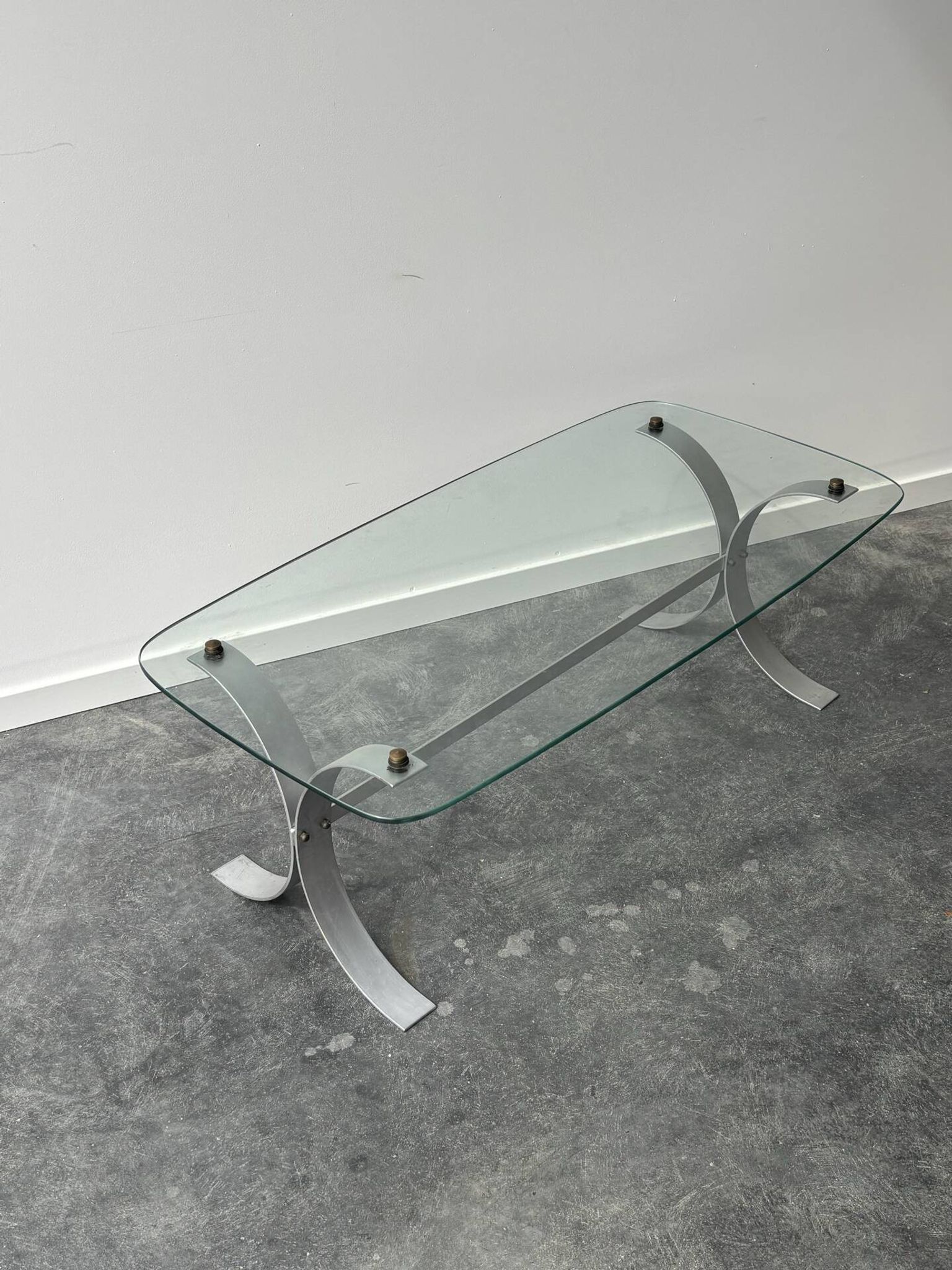 Design coffee table in brushed metal with a glass top, 1970s.