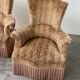 Pair of sculptural Hollywood Regency lounge chairs with original fringed upholstery