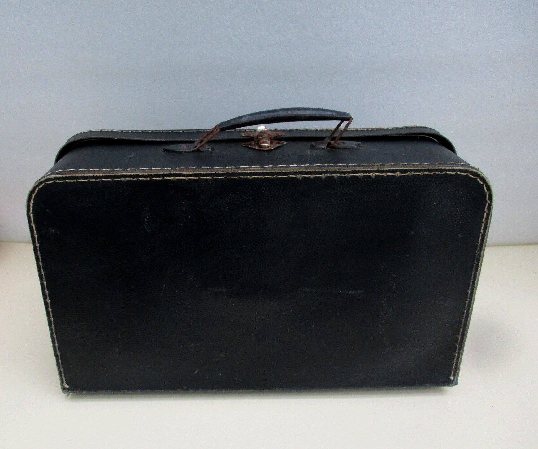 Small suitcase in old navy blue cardboard