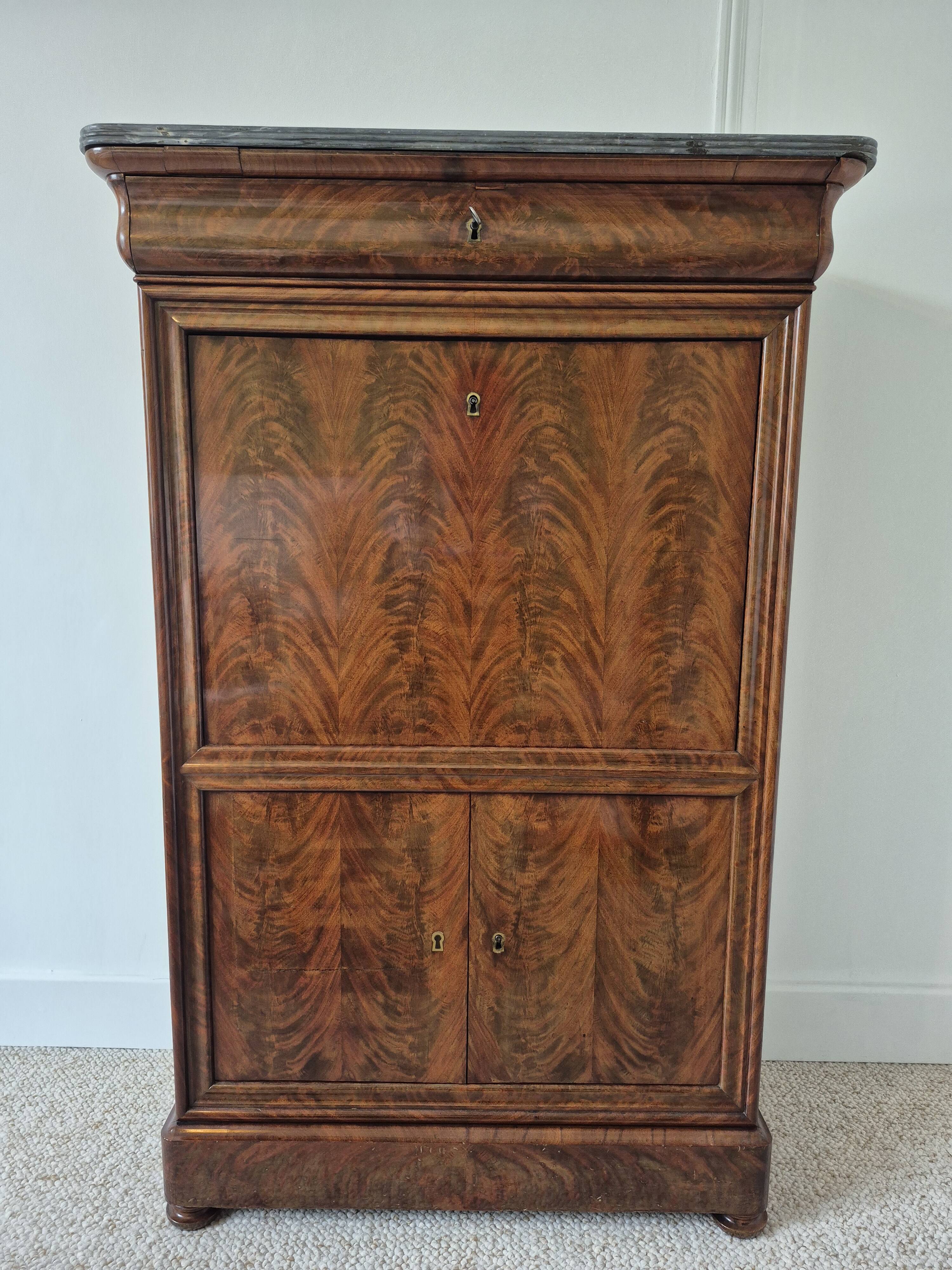 Mahogany secretary desk with marble top and interior mirror.