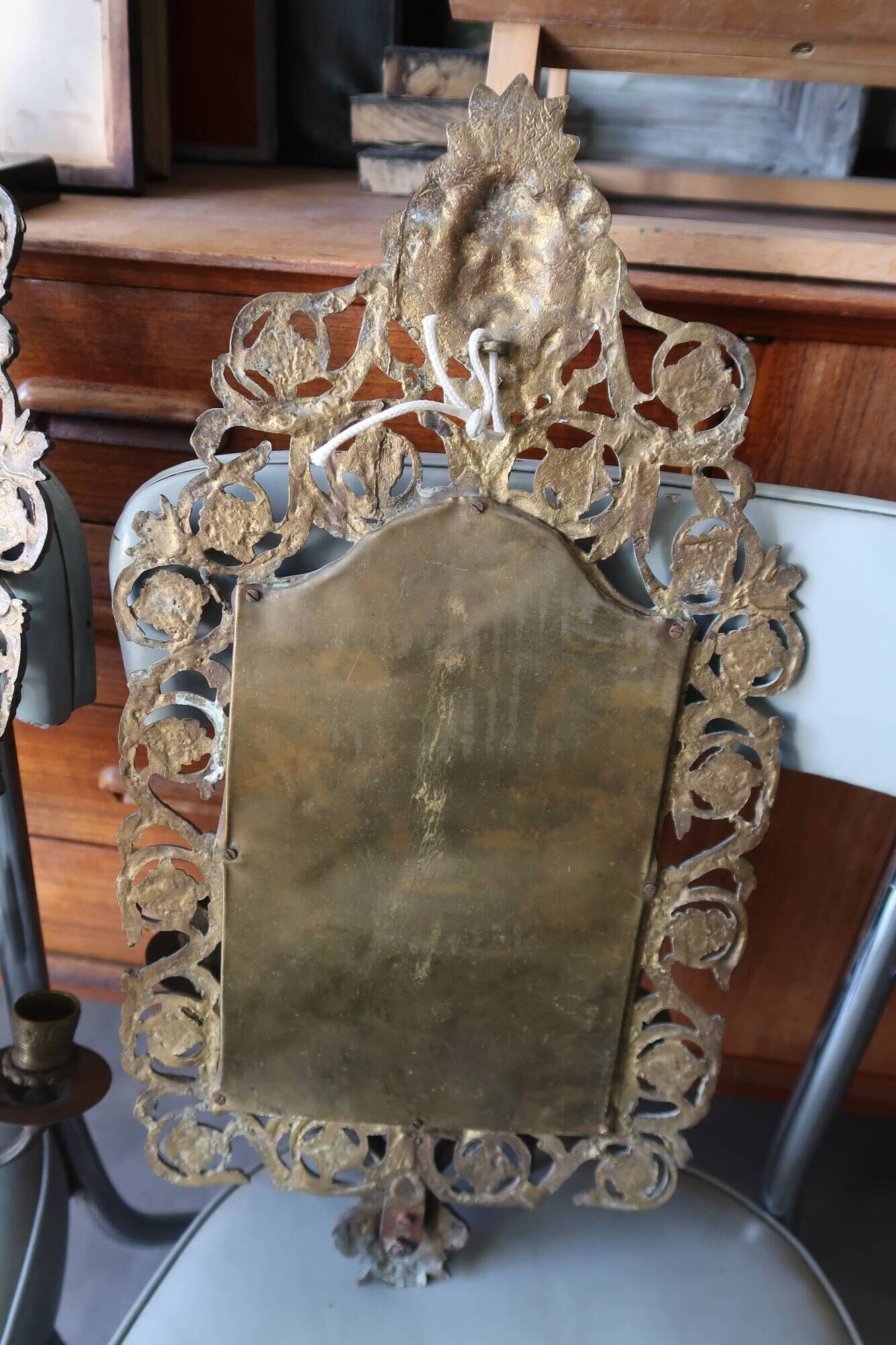 Pair of mirror wall sconces with brass candle holders.