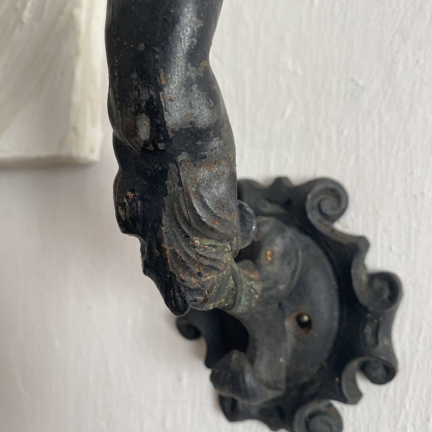 Antique cast iron coat hook with swimmer and shell basin.