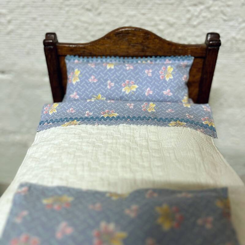 Old doll's bed in varnished wood