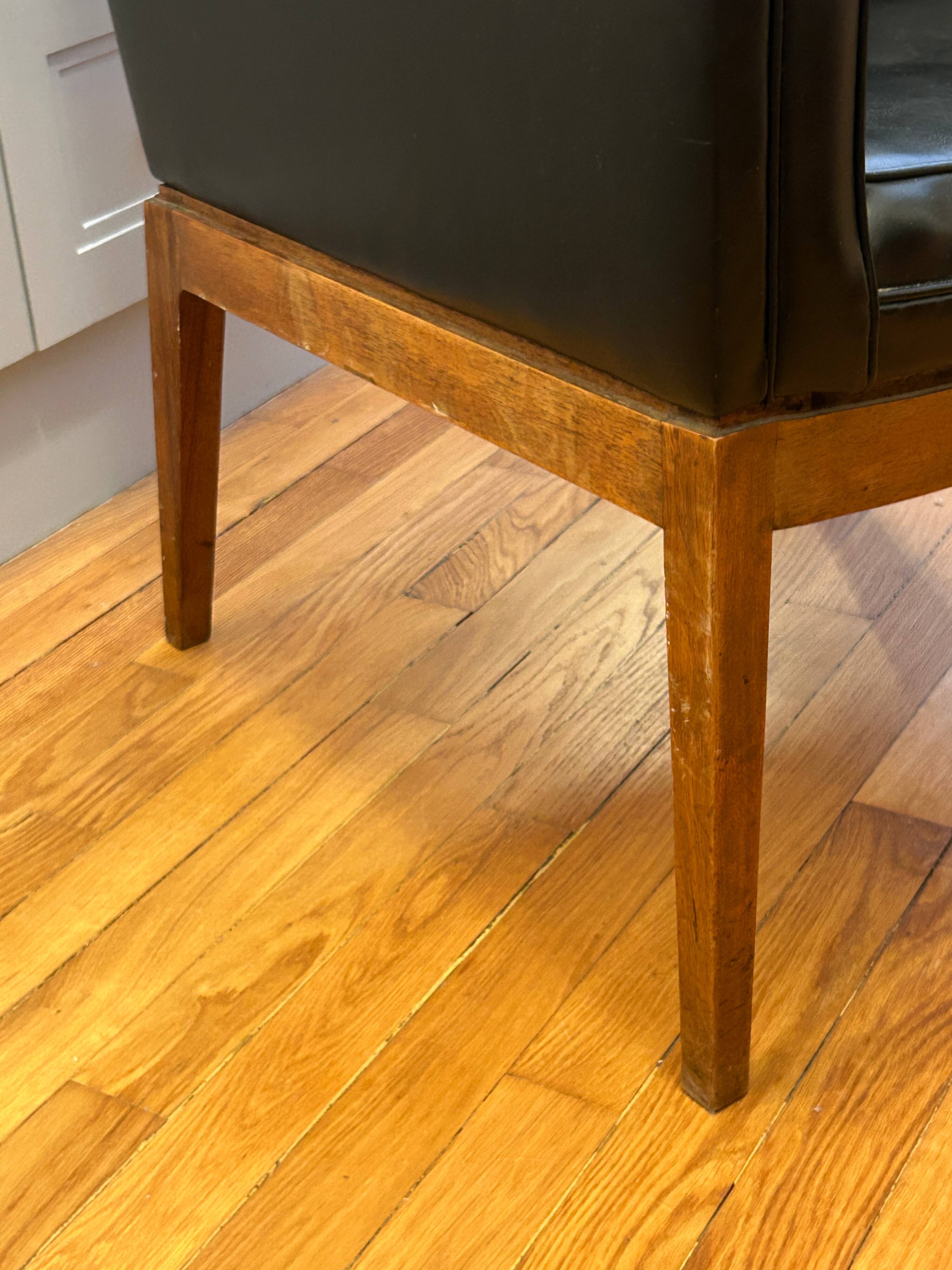 Modernist armchair in wood and black synthetic leather, circa 1960