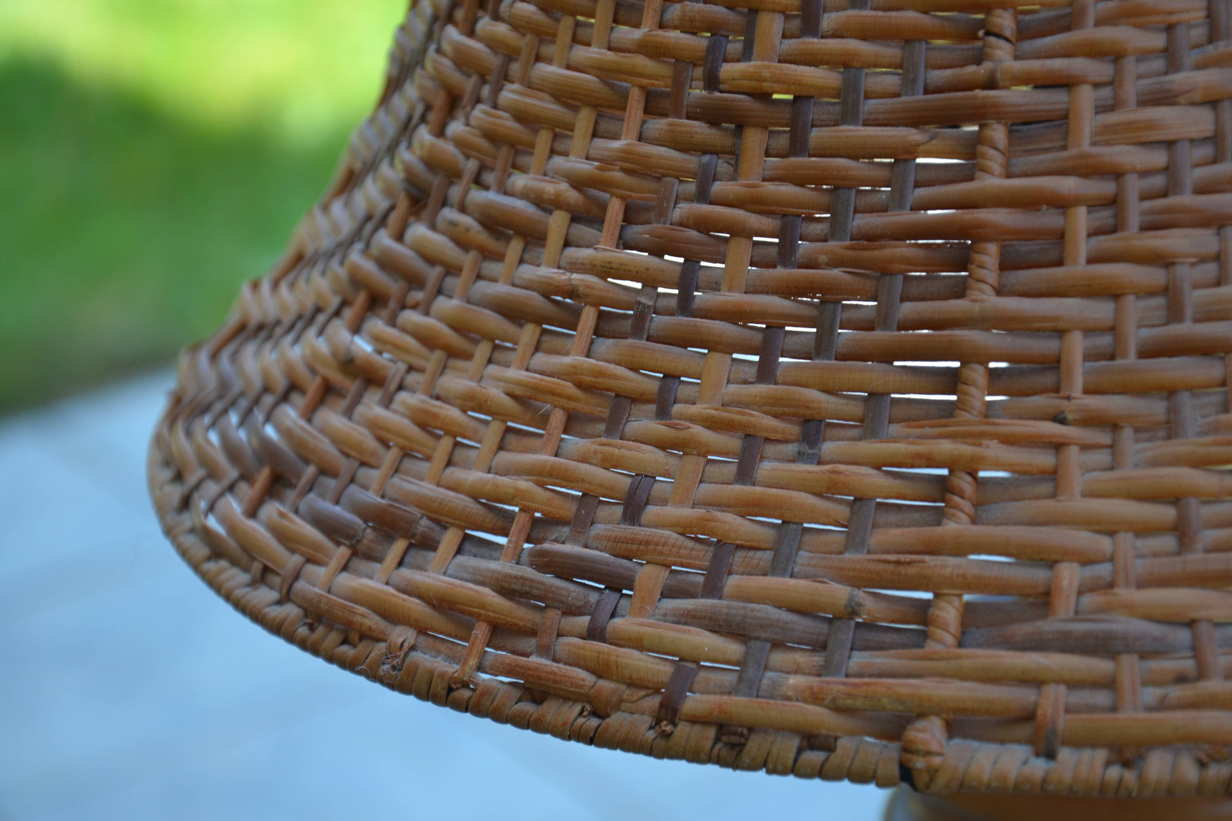 Large wooden lamp with a woven rattan shade.