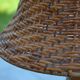 Large wooden lamp with a woven rattan shade.