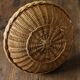 Round wicker basket with a rigid handle.