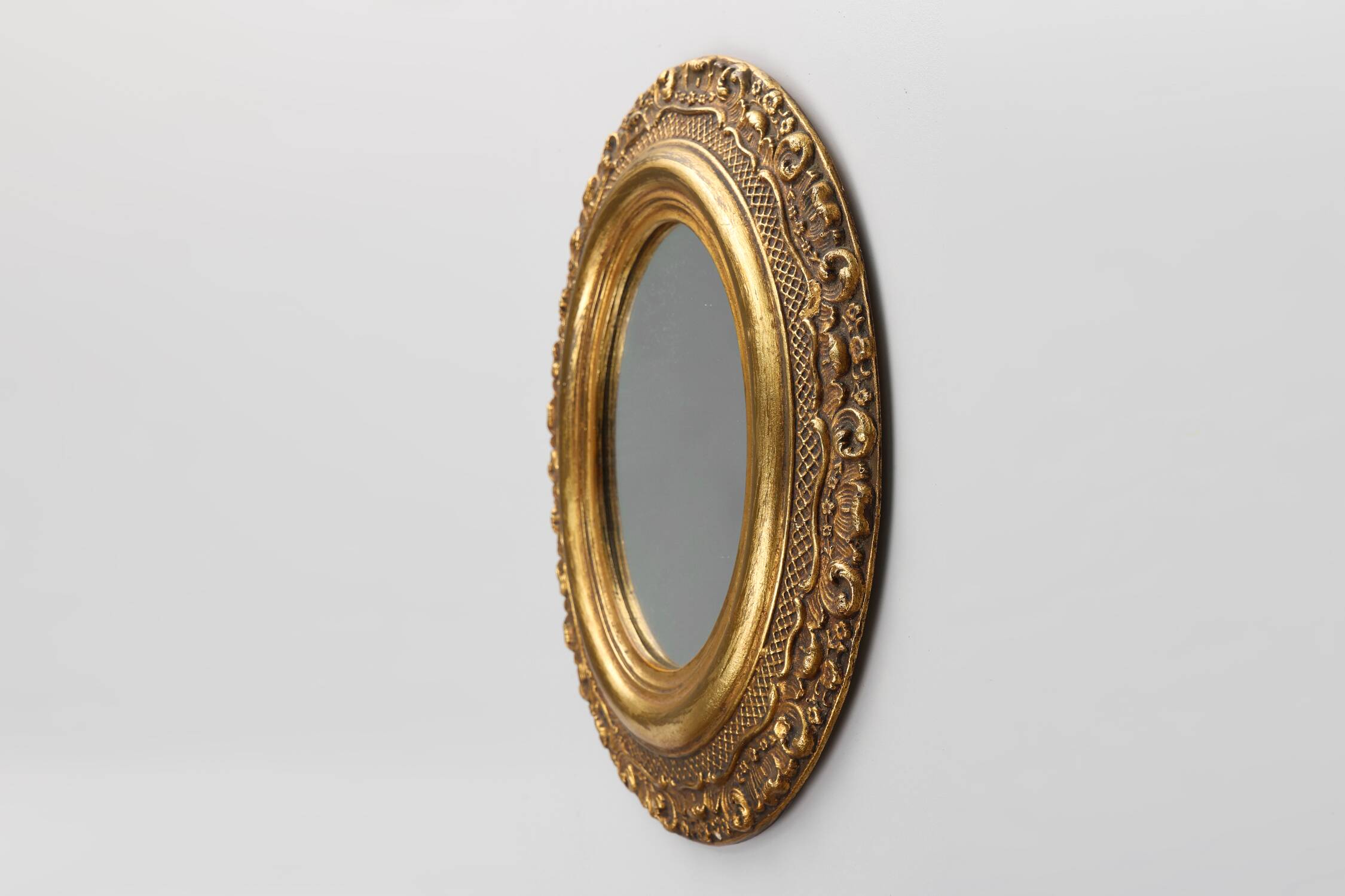 French Baroque style oval mirror in gilded wood with floral decorations