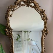 Rocaille style mirror from the 20th century in wood and gilded stucco, Putto on the pediment