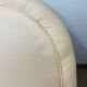 Pale pink upholstered armchair with wooden legs.