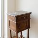 Antique wooden bedside table with a marble top.