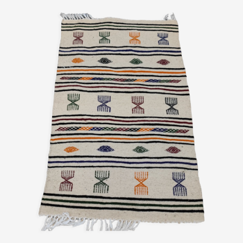 White carpet with multicolored Berber patterns woven hands