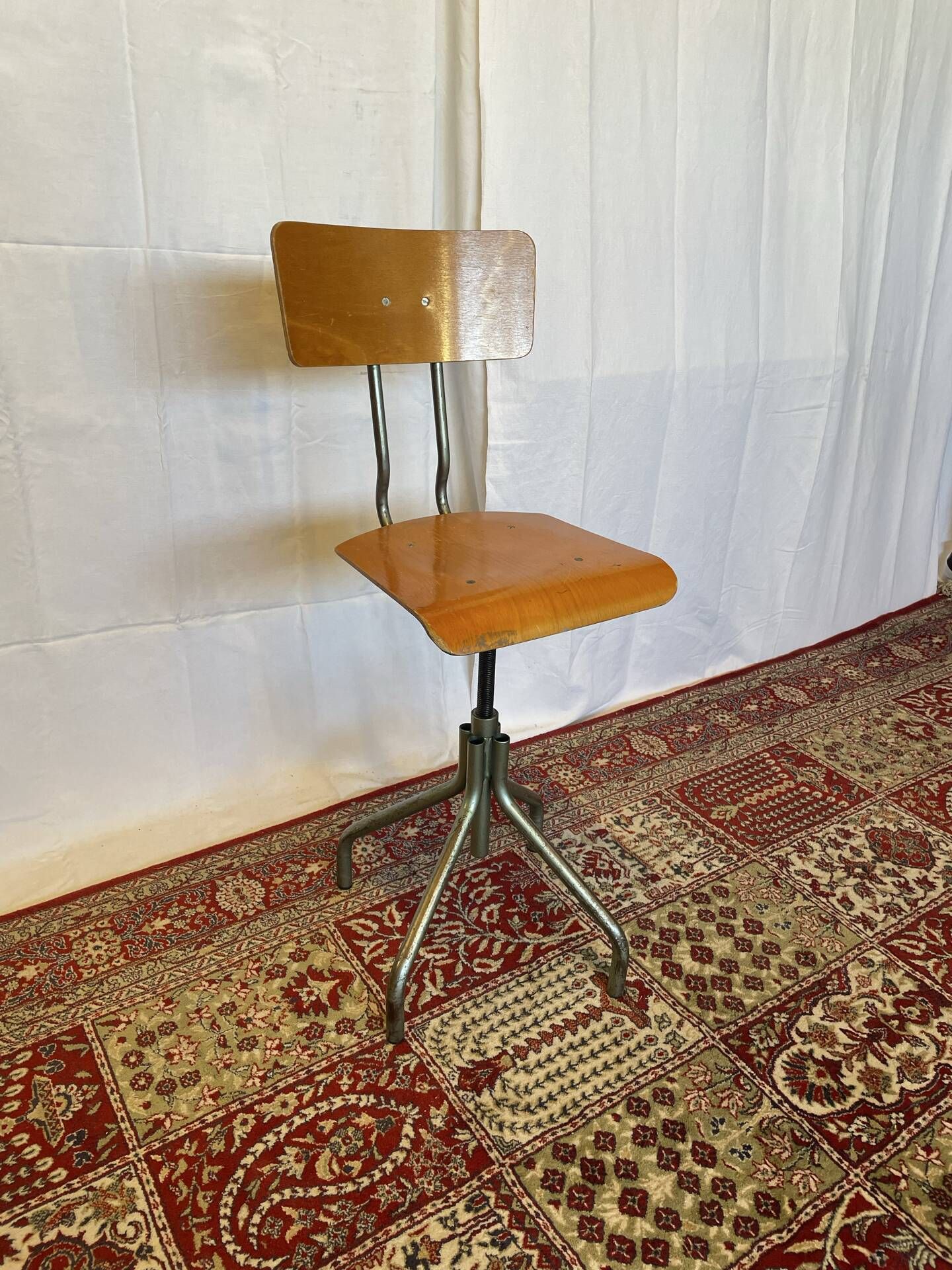 Old high workshop chair made of wood and metal.