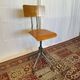 Old high workshop chair made of wood and metal.