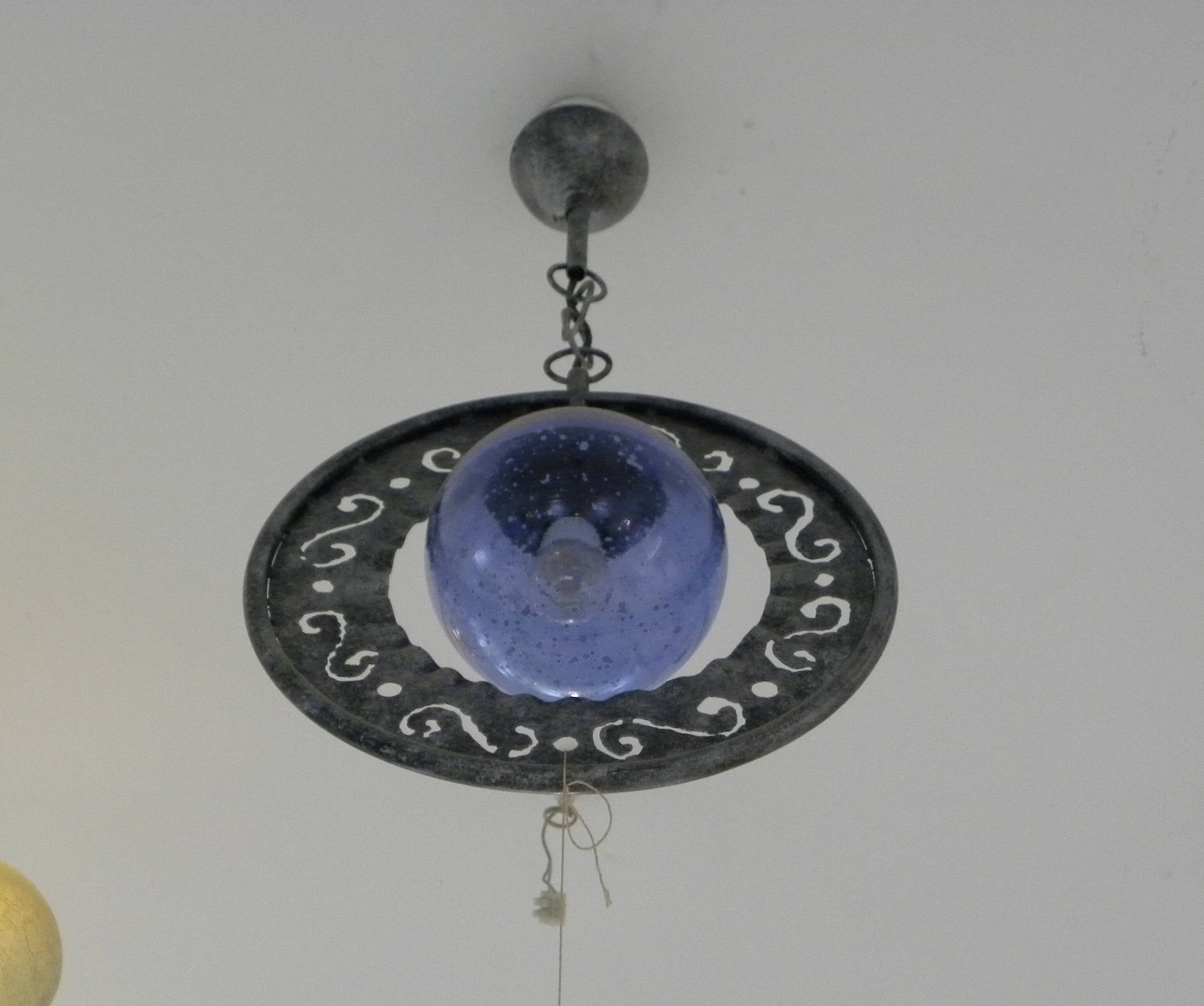 Patinated metal chandelier with cobalt blue blown glass in a rustic style.