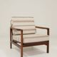 Fauteuil vintage avec des coussins en tissu naturel rayé.