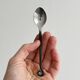 Two small hammered metal teaspoons with a snail pattern.