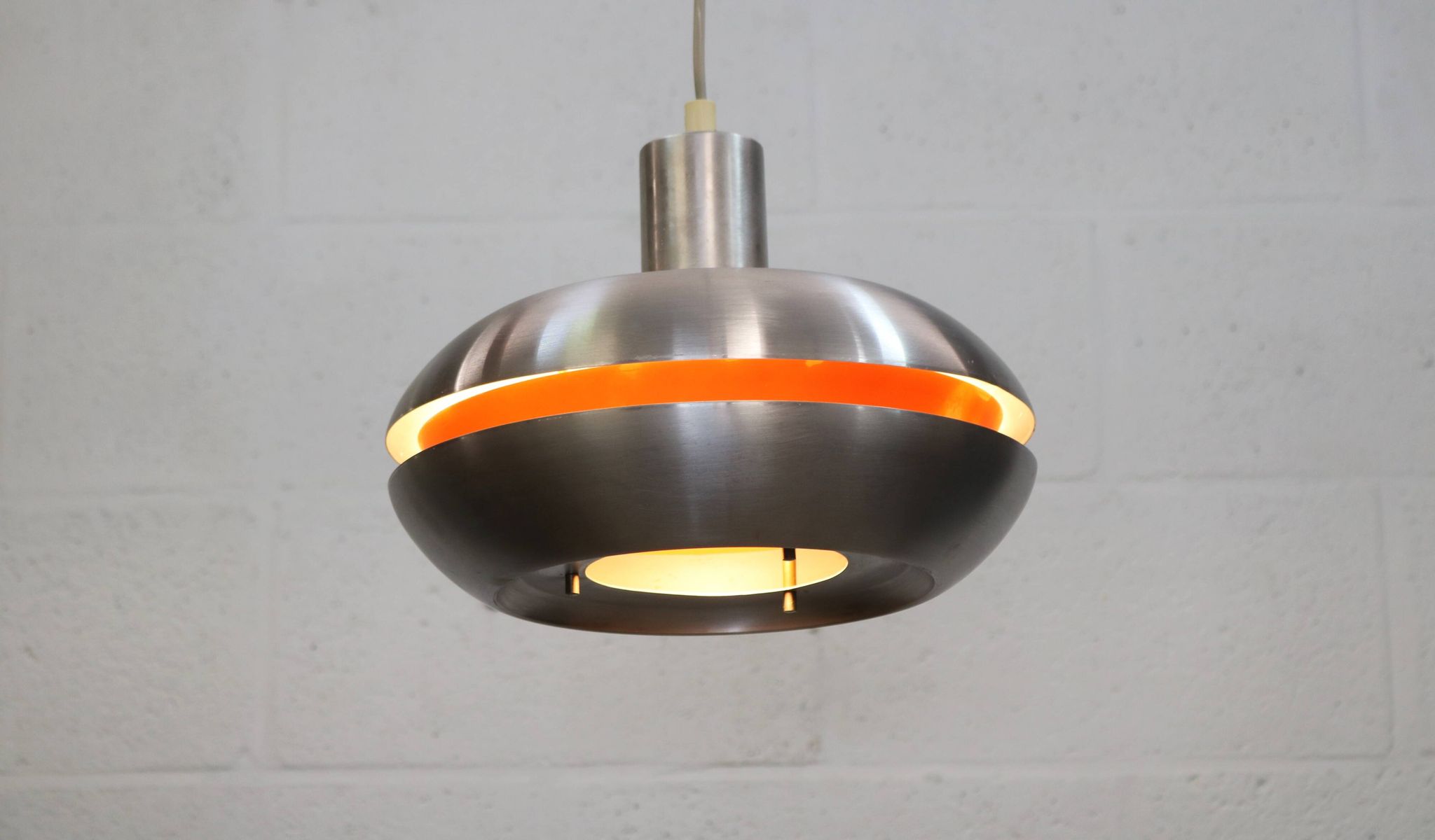 Ancienne lampe de design danois de l'ère spatiale en aluminium avec intérieur orange.