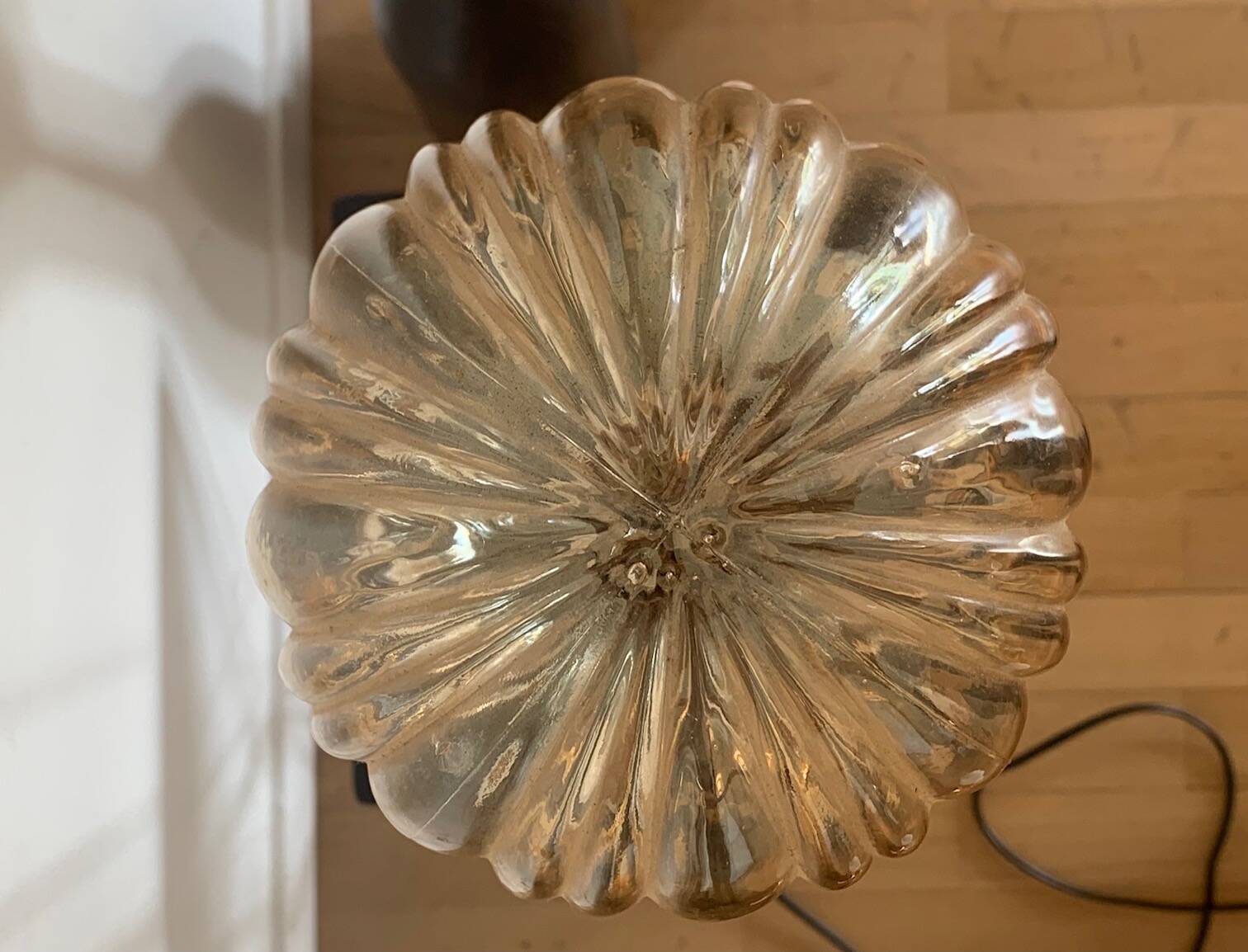 Table lamp with a golden striated globe and a golden base